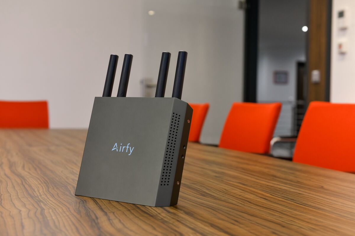Airfy Access Point auf einem Besprechungstisch, noch mit dem früheren Airfy-Schriftzug.